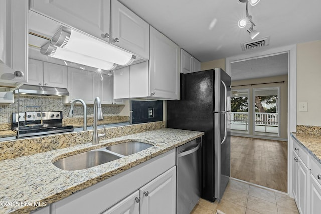 kitchen with visible vents, a sink, appliances with stainless steel finishes, white cabinetry, and backsplash