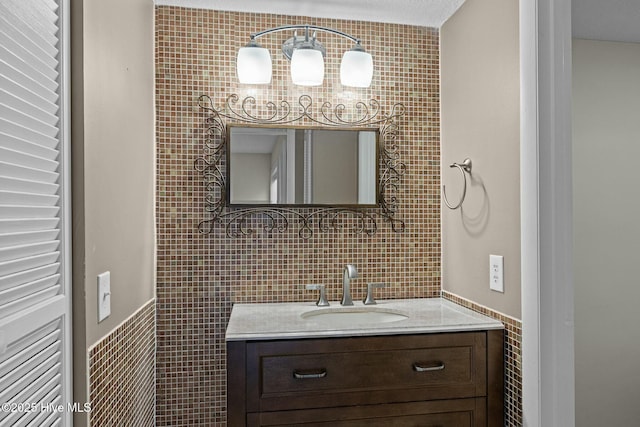 bathroom featuring vanity, tile walls, and wainscoting