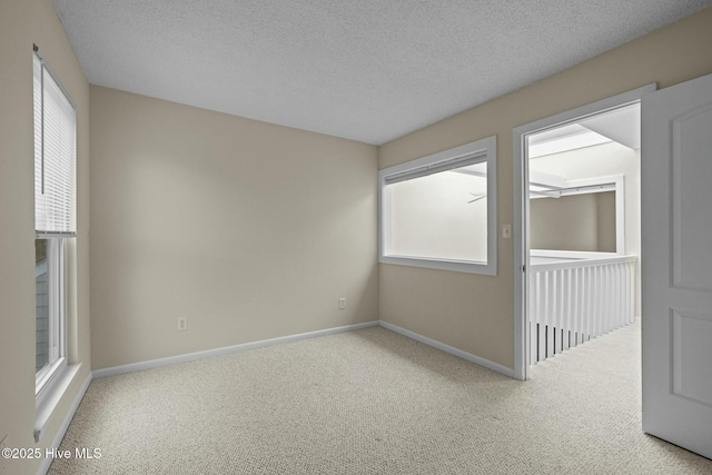 empty room featuring baseboards, carpet, and plenty of natural light