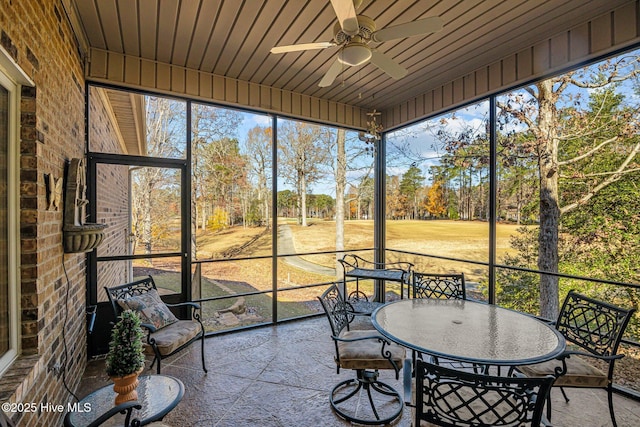 sunroom with ceiling fan and outdoor dining area