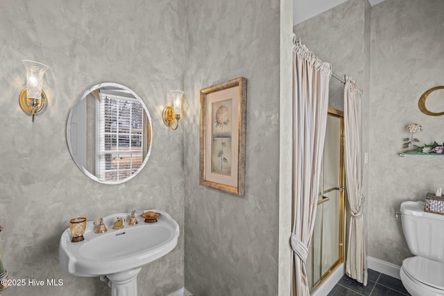 full bathroom featuring toilet, tile patterned floors, a shower stall, and a sink