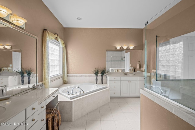 bathroom featuring a sink, tile patterned floors, two vanities, a shower stall, and a garden tub