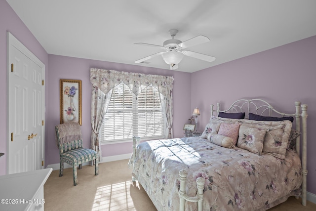 bedroom featuring baseboards, ceiling fan, and light carpet