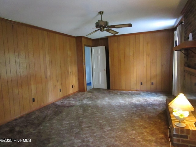 unfurnished living room with wood walls, carpet flooring, and a ceiling fan