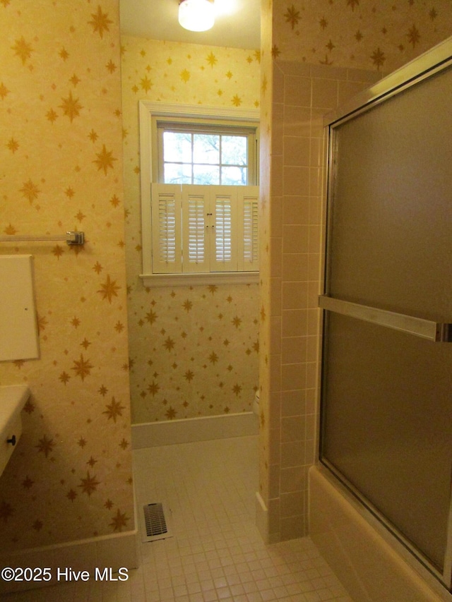 bathroom featuring visible vents, tile patterned floors, wallpapered walls, and shower / bath combination with glass door