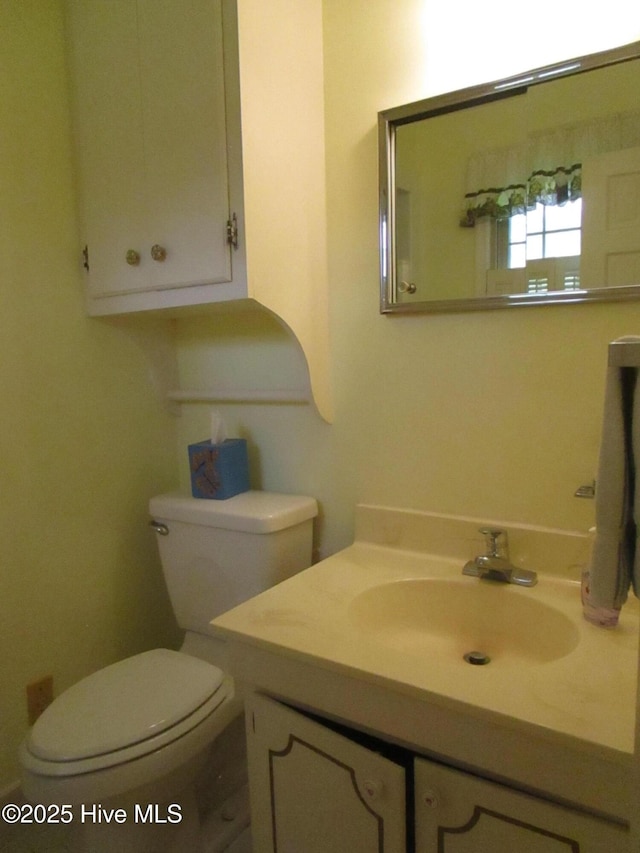 half bathroom with vanity and toilet