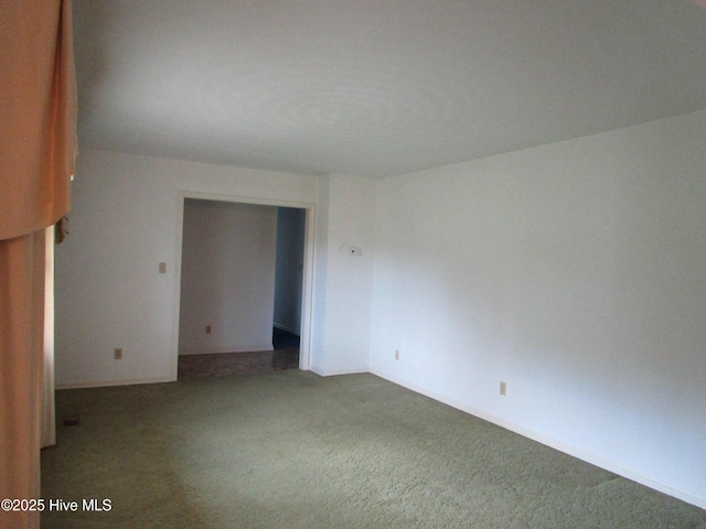 unfurnished room featuring carpet floors and baseboards