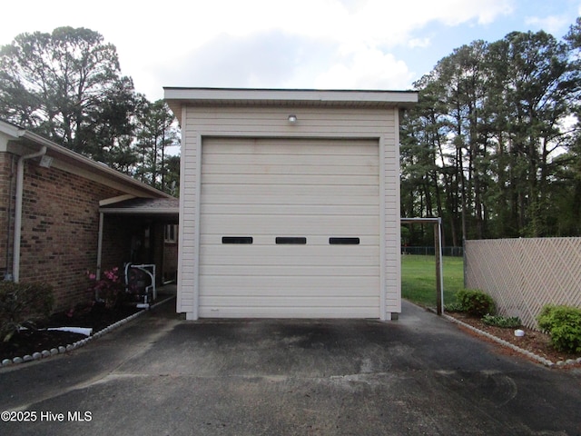 detached garage featuring fence