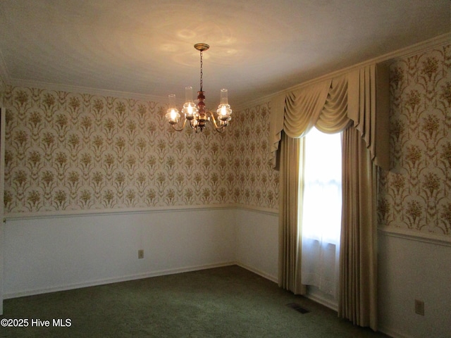 carpeted spare room featuring wallpapered walls, an inviting chandelier, and wainscoting