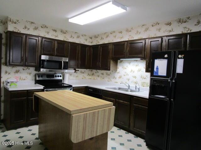 kitchen featuring wallpapered walls, light floors, and stainless steel appliances