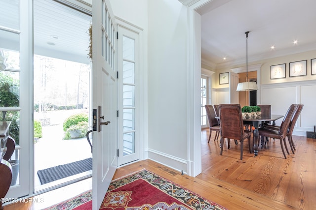 entryway featuring hardwood / wood-style floors, crown molding, visible vents, and recessed lighting