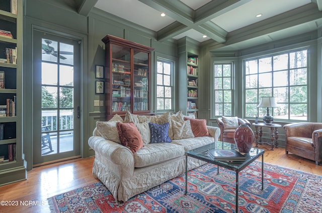 living area featuring coffered ceiling, wood finished floors, beamed ceiling, and a wealth of natural light