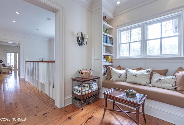 living room featuring recessed lighting, built in features, light wood-type flooring, and crown molding