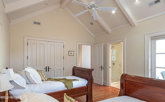 bedroom with visible vents, light wood-style flooring, a closet, and beamed ceiling