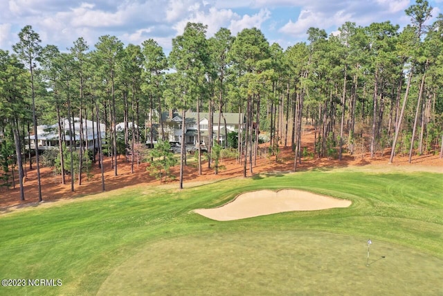 surrounding community featuring view of golf course and a lawn
