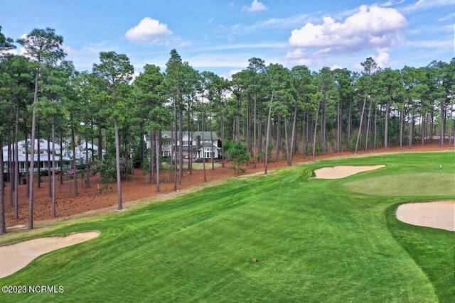 view of property's community featuring a yard and view of golf course
