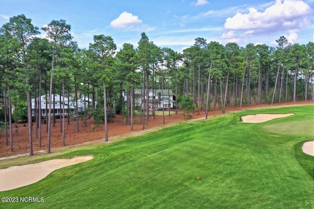 view of community with golf course view and a lawn