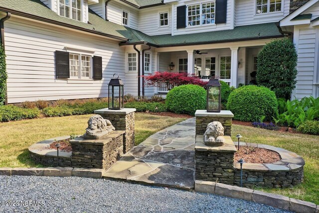 entrance to property featuring a shingled roof