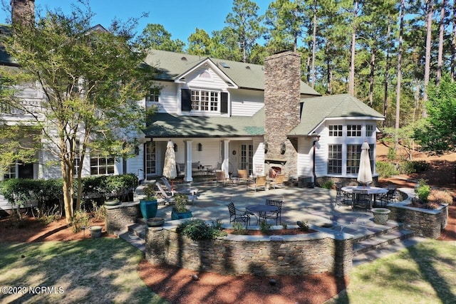rear view of property featuring a patio and outdoor dining area