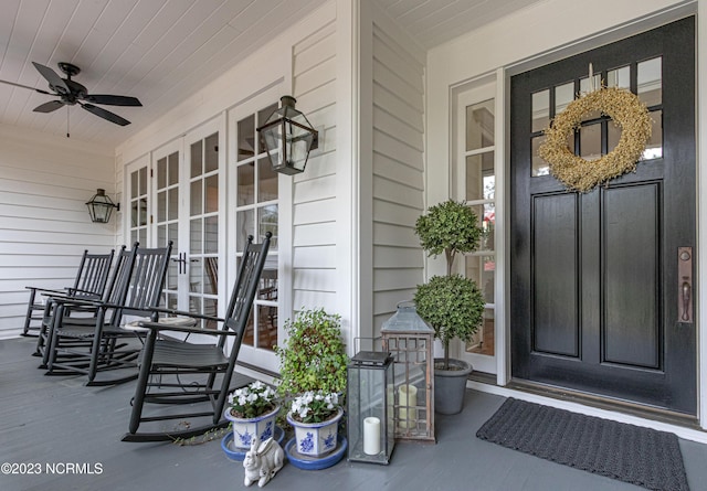 entrance to property with a porch and ceiling fan