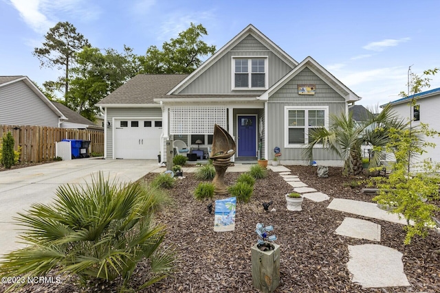 craftsman house with covered porch, fence, an attached garage, concrete driveway, and board and batten siding