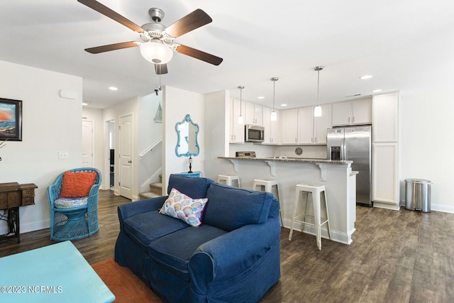 living room featuring a ceiling fan, dark wood-style flooring, baseboards, and recessed lighting