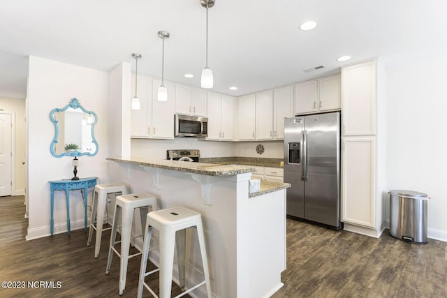 kitchen featuring a peninsula, stainless steel appliances, visible vents, dark wood-style flooring, and baseboards