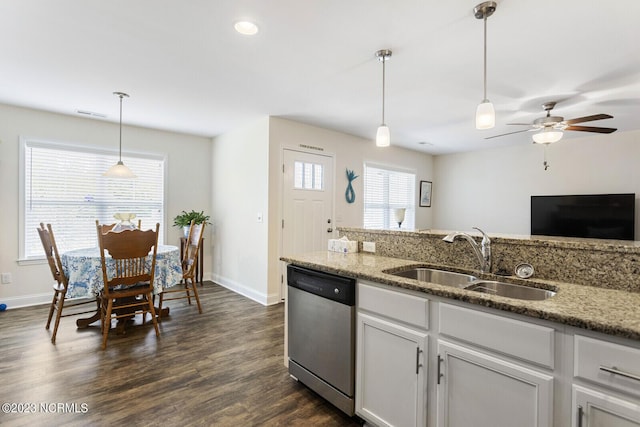 kitchen with a sink, dark wood-type flooring, stainless steel dishwasher, light stone countertops, and baseboards