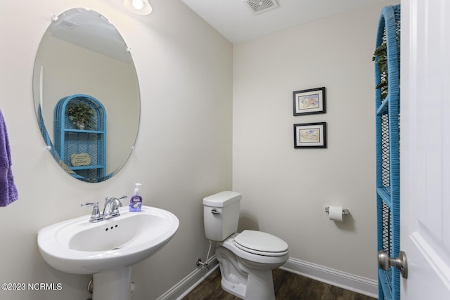bathroom featuring wood finished floors, visible vents, baseboards, and toilet