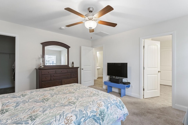 bedroom featuring light colored carpet, visible vents, baseboards, and a spacious closet
