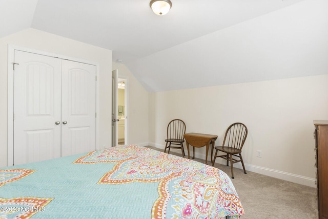 carpeted bedroom with vaulted ceiling, a closet, and baseboards