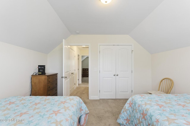 bedroom featuring lofted ceiling, a closet, and carpet