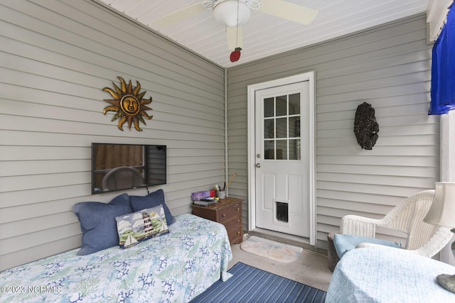bedroom with wood walls and a ceiling fan