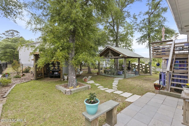 view of yard with a gazebo, fence, stairs, and a patio area
