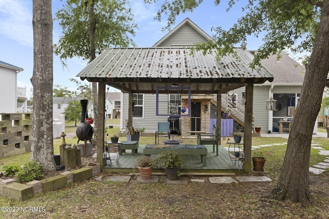 back of house featuring a deck, a gazebo, and metal roof