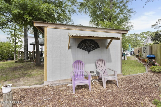 view of outbuilding featuring an outdoor structure and fence