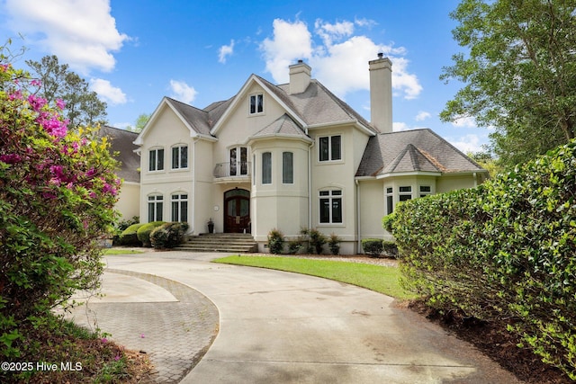 210 Sumter Ct, Havelock, NC 28532 - french country inspired facade featuring french doors, stucco siding, a chimney, and driveway