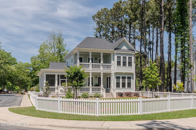 9298 W Lake Rd, Calabash, NC 28467 - rear view of property featuring a balcony, a shingled roof, a fenced front yard, and covered porch