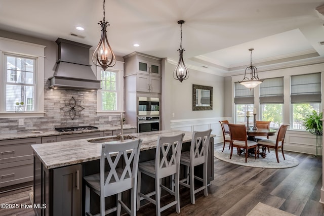 9298 W Lake Rd, Calabash, NC 28467 - kitchen featuring a sink, stainless steel appliances, backsplash, premium range hood, and light stone counters