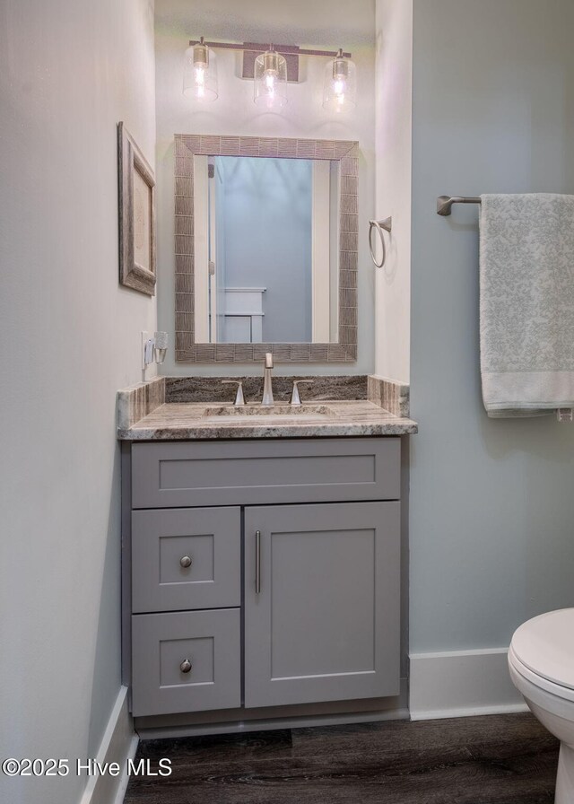 9298 W Lake Rd, Calabash, NC 28467 - bathroom with wood finished floors, baseboards, vanity, and toilet