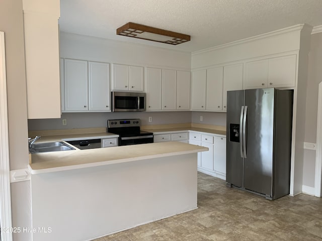 kitchen with appliances with stainless steel finishes, a sink, a peninsula, light countertops, and a textured ceiling