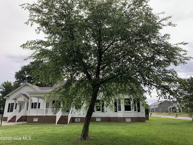 view of front of home featuring crawl space, covered porch, and a front yard