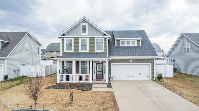 craftsman inspired home with board and batten siding, fence, covered porch, concrete driveway, and roof with shingles