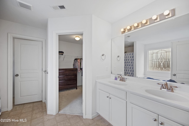 full bath featuring a sink, double vanity, and visible vents