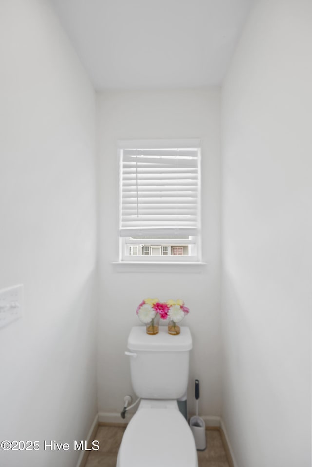 bathroom with toilet and baseboards