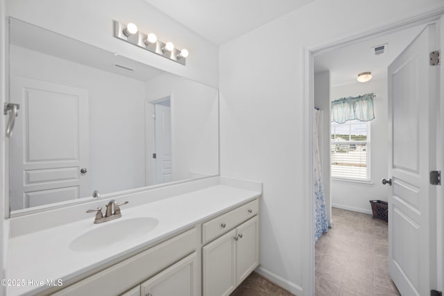 bathroom with vanity, baseboards, visible vents, and tile patterned floors