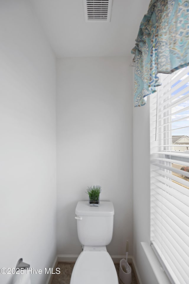 bathroom featuring toilet, visible vents, and baseboards