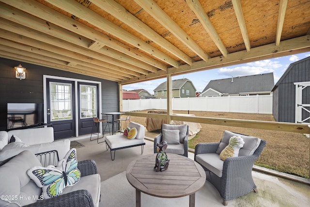 view of patio with fence, an outdoor hangout area, a shed, and an outdoor structure