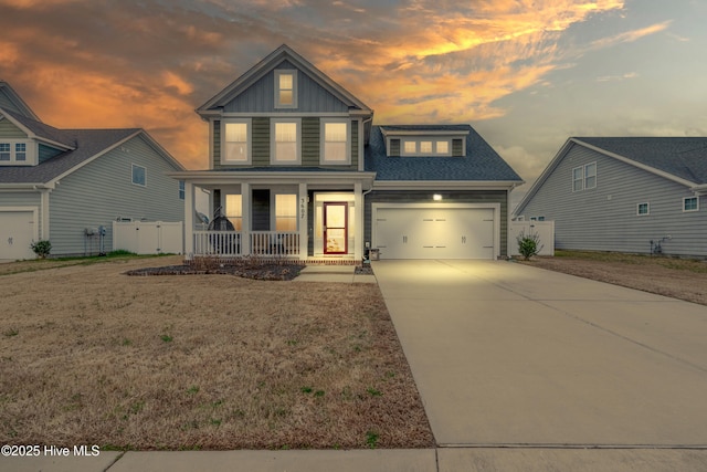 view of front of house featuring board and batten siding, fence, an attached garage, concrete driveway, and a porch