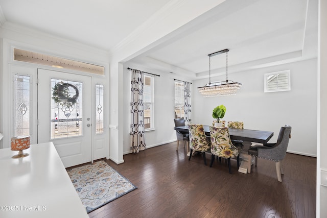 foyer entrance with ornamental molding, a raised ceiling, baseboards, and wood finished floors